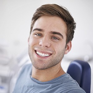 Young male patient smiling in dental chair