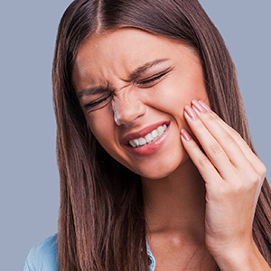 Young woman in pain holder her cheek